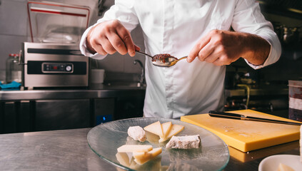 Chef in a restaurant garnish cheese plate
