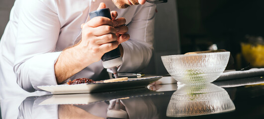 the chef decorates a plate of foie gras with sauce © bodiaphoto