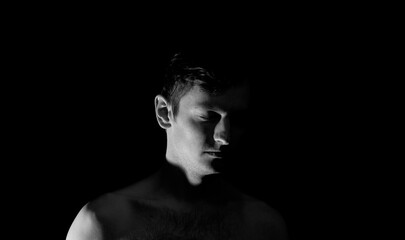 Fototapeta na wymiar black and white photo portrait of a guy, in dramatic lighting