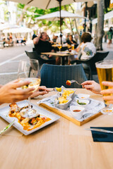 a glass of beer and wine on a table with utensils two girls have dinner together in a restaurant on the terrace in summer