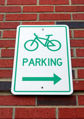 Obraz premium Wall Mounted Bicycle Parking Sign against a Brick Building