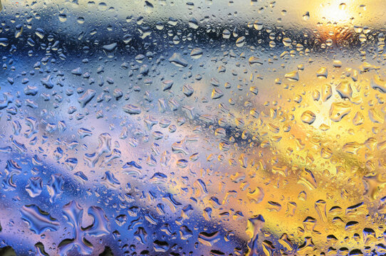 Abstract blurred image of sunset sky and sea with water drops on glass