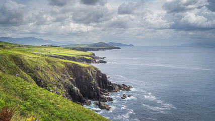 Fototapeta na wymiar Cliffs, beautiful coastline and mountain range in Dingle Peninsula, scenic Wild Atlantic Way with dramatic storm sky, Kerry, Ireland