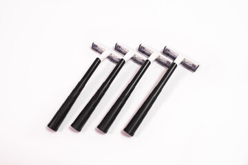 Four black disposable razors isolated on white background