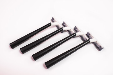 Four black disposable razors isolated on white background
