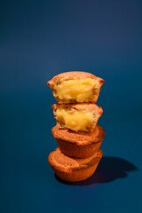 Pasticciotti . Typical pastries from the south of italy, the Apulia region. Buns with cream on a blue background. Hard light, 
