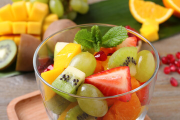 Delicious fresh fruit salad in dish on table, closeup view