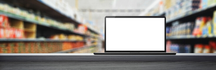 Laptop on a table with a supermarket aisle background