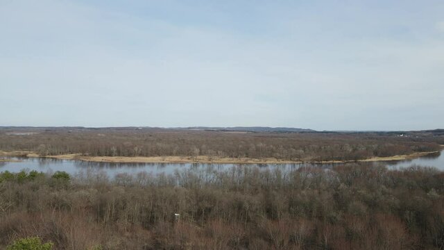 A beautiful aerial 4K shot of the Chippewa River in Durand, Wisconsin surrounded by a leafless forest