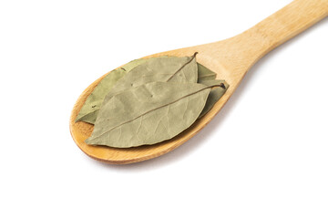 Top view, closeup of dried bay leaves on a wooden spoon