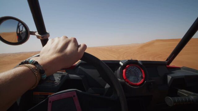 Driving a sand buggy in the desert. Point of view of driving an offroad vehicle on sand dunes in the desert