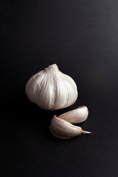 still life of garlic heads and garlic cloves on black background.  healthy ingredients food concept.