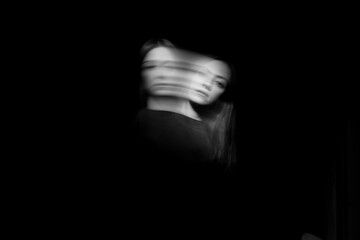 Blurred female portrait in the dark. - obrazy, fototapety, plakaty