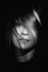 Blurred female portrait in the dark.