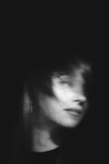 Blurred female portrait in the dark.