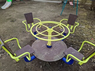 children's circular carousel on the playground in the spring