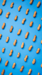 Pattern of isolated peanuts on blue background. Top view.