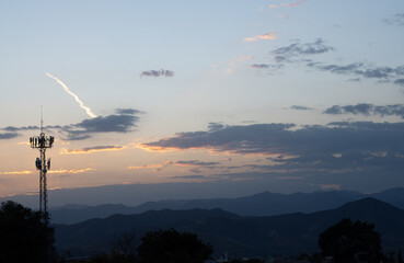 hermoso paisaje con un cielo azul y varias nubes, hay árboles y una antena