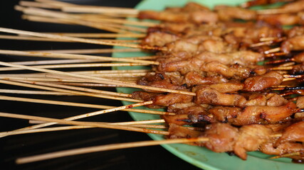 Lots of chicken satay on the plate. Indonesian special food. Focus selected