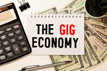 Notebook with Notes GIG ECONOMY office tools on a blue background . Concept GIG ECONOMY