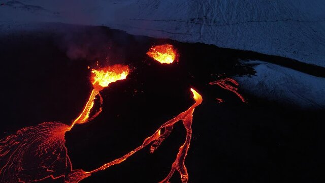 A beautiful shot of burning red lava flowing from a volcano in 4K