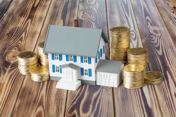 Model of a mini house with coins on a table