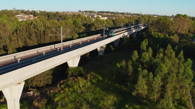 Aerial view of a Sydney Metro train going past on the skyrail (above ground) track at Kellyville, NSW, Australia.