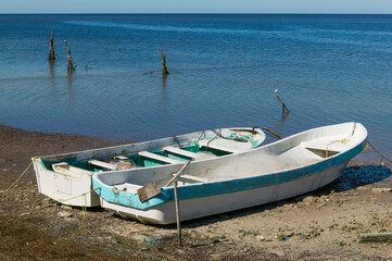 Two Mexican Panga fishing boats beached on the sand at low tide along the Bay of Campeche, Campeche, Mexico.