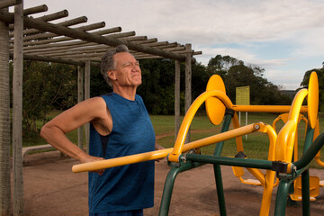 Fototapeta premium Senior Man working out at an outdoor fitness park in Parque Das Garças, Brasilia