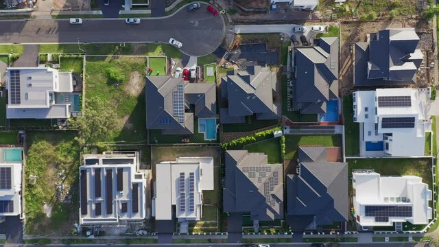 Top down aerial flyover of modern upmarket houses, many with rooftop solar, Sydney, Australia.
