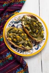 Molletes with poblano rajas and cheese on white background. Mexican food
