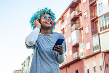 afro american girl smiling with headphones and mobile phone in the city