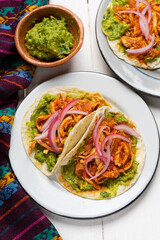 Chicken tinga tacos with guacamole and onion on white background. Mexican food