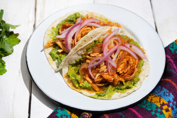 Chicken tinga tacos with guacamole and onion on white background. Mexican food