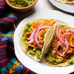 Chicken tinga tacos with guacamole and onion on white background. Mexican food