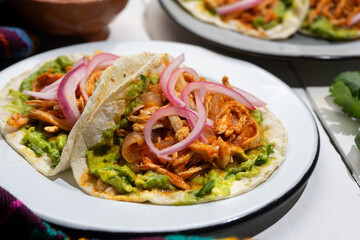 Chicken tinga tacos with guacamole and onion on white background. Mexican food
