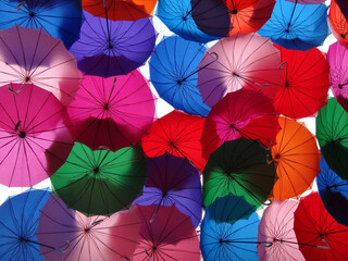 Low angle of multicolored umbrellas covering the street