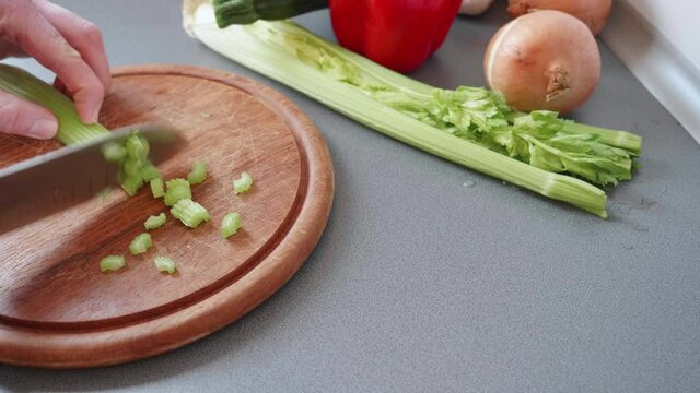 Slow motion of chopping celeriac into small pieces.