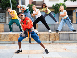 Portrait of preteen boy performing hip hop at outdoors group dance class