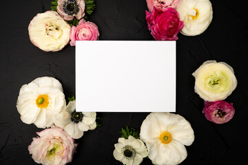 Obraz na płótnie Canvas Blank stationery card with fresh ranunculus flowers on black textured background