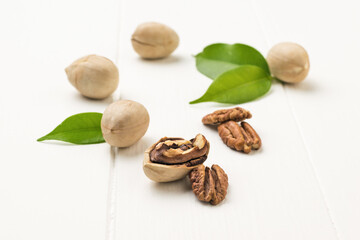 Ripe pecans in a light shell on a white wooden table.
