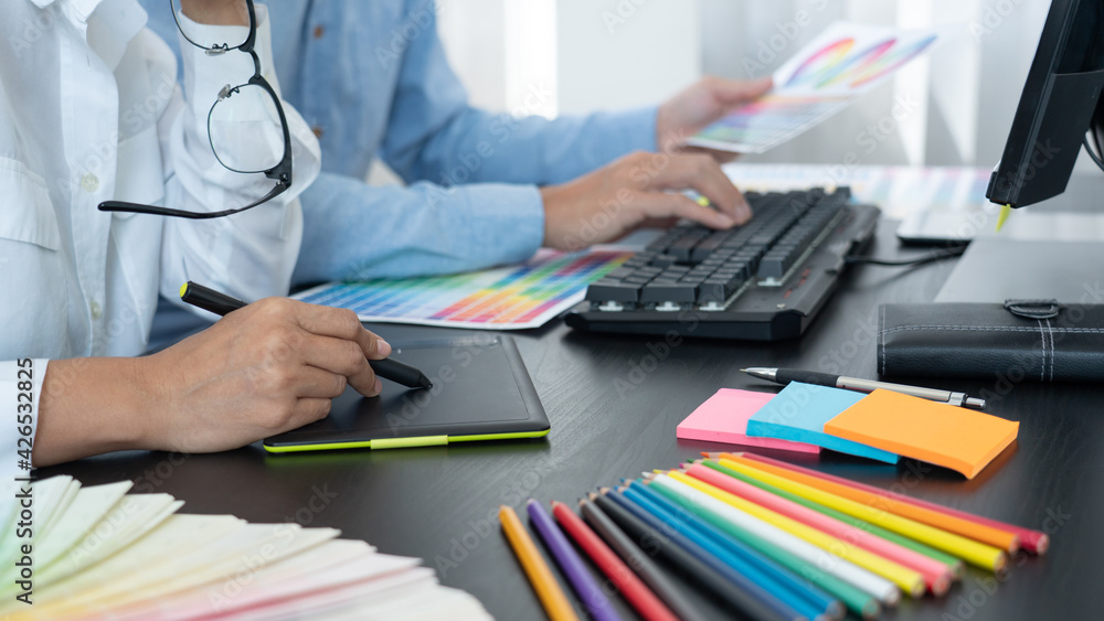 Aufkleber graphic designer or creative working together coloring using graphics tablet and a stylus at desk wi