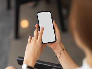 Over shoulder closeup view of female hands touching on mock-up smartphone screen