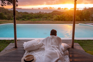 Happy man traveler enjoy Beautiful ocean view, Tourist relaxing in tropical luxury resort with...