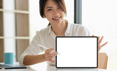 Smiling beautiful asian businesswoman showing blank tablet pc monitor, with copyspace area for slogan or text message.
