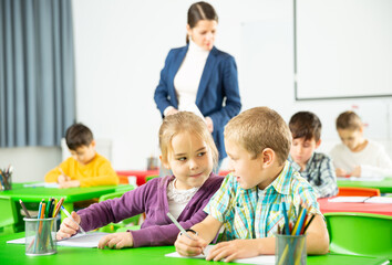 Happy pupils chattering sitting at lesson in elementary school. High quality photo