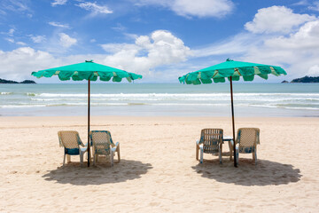 Beach umbrella made of palm leafs on a perfect white beach in front of sea in at Patong Beach
