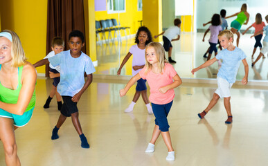 Group of tweens exercising with female coach in choreography class.