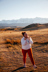 Happy young woman in Kurrai steppe in Altai Republic in early autumn