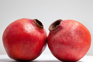 Two pomegranate fruits isolated on a white background.